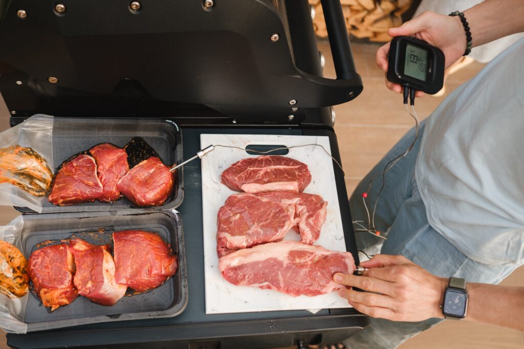 Preparation for Cooking meat on an open grill with temperature check.